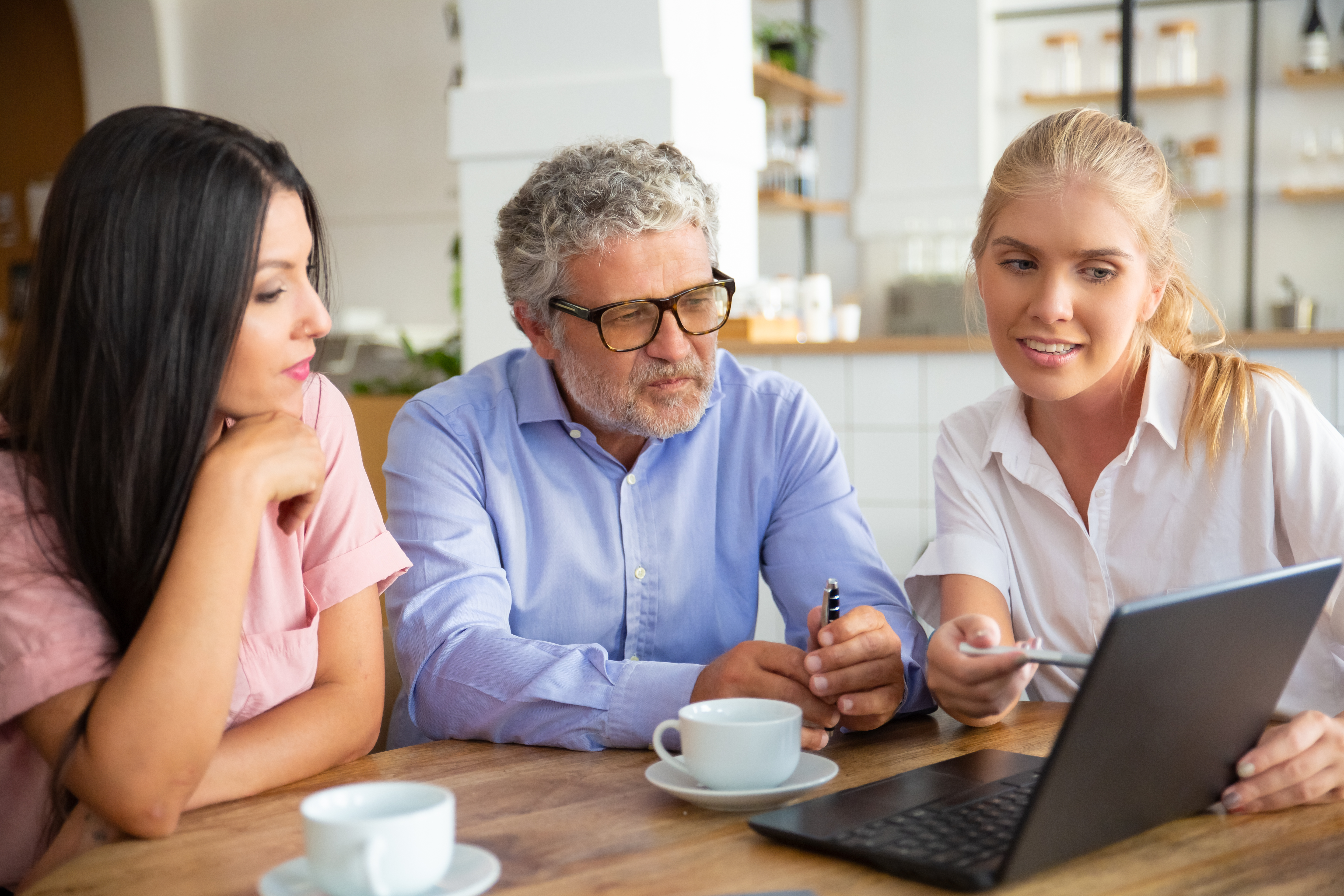 Female Agent showing a presentation on the laptopn with two people beside her, a mature man and a young girl